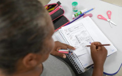 Adultos sendo alfabetizados na escola.