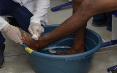 Estudantes de medicina da Facit realizam lava-pés em pessoa em situação de rua durante o Mutirão Pop Rua Jud, na Escola Jardenir Jorge Frederico, em Araguaína