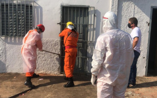 Bombeiros abrindo a porta da residência.