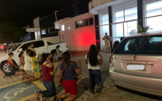 Familiares de paciente se ajoelham em frente ao HDO e rogam a Deus pela vida do ente querido.