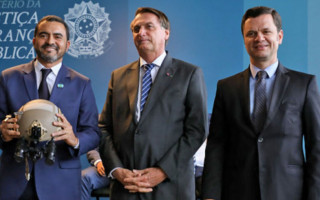 Ladeado pelo presidente Bolsonaro e o ministro Anderson Torres, o governador Wanderlei Barbosa segura um dos capacetes balísticos