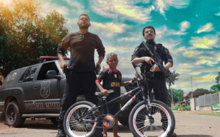 Pequeno Alerrandro com os policiais civis da DEIC após receber bicicleta de presente de aniversário