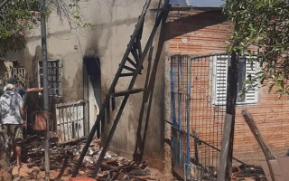Moradores combatendo chamas com mangueiras de jardim