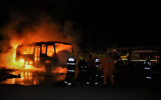 Bombeiros militares combatem o incêndio que destruiu o ônibus escolar, em Palmas.