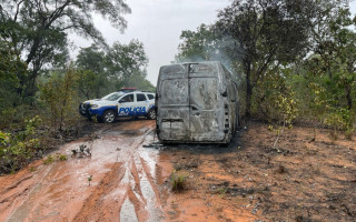 Van incendiada numa estrada da zona rural. 