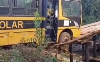 Ônibus ficou preso após buraco se abrir em ponte de madeira