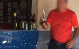 Policial militar aposentado mostra arma para pessoas em bar