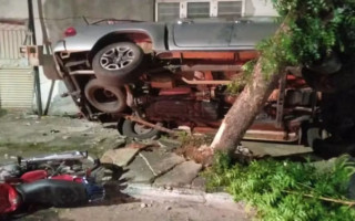 Caminhonete ficou presa entre árvore e parede de casa durante acidente