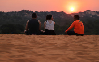  Turistas contemplam pôr do sol das Dunas