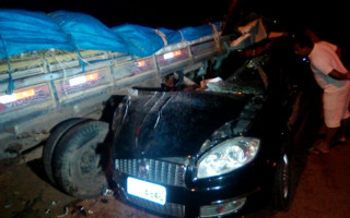 Carro de passeio bate em caminhão estacionado.