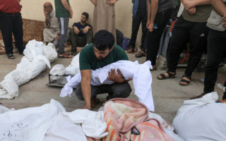 Homem palestino segura o corpo de seu bebê morto em um ataque israelense, no centro da Faixa de Gaza