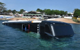 Durante o embarque o ônibus não conseguiu parar, rompeu a grade de proteção e caiu no rio. 