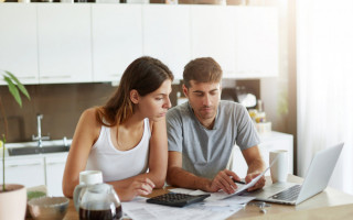 Ilustração de casal analisando finanças pessoais 