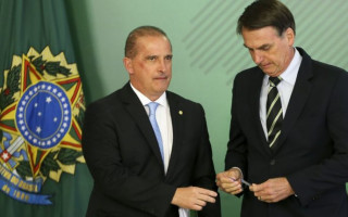 O ministro da Casa Civil, Onyx Lorenzoni, e o presidente Jair Bolsonaro, durante cerimônia de assinatura do primeiro decreto que flexibilizou a posse de armas no país