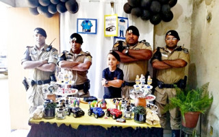 Aniversariante posa para fotos, imitando Policiais em postura que demonstra coragem.