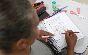 Adultos sendo alfabetizados na escola.