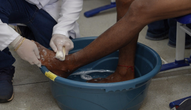 Estudantes de medicina da Facit realizam lava-pés em pessoa em situação de rua durante o Mutirão Pop Rua Jud, na Escola Jardenir Jorge Frederico, em Araguaína