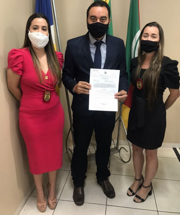 Ygor ladeado pelas delegadas Ana e Sarah 