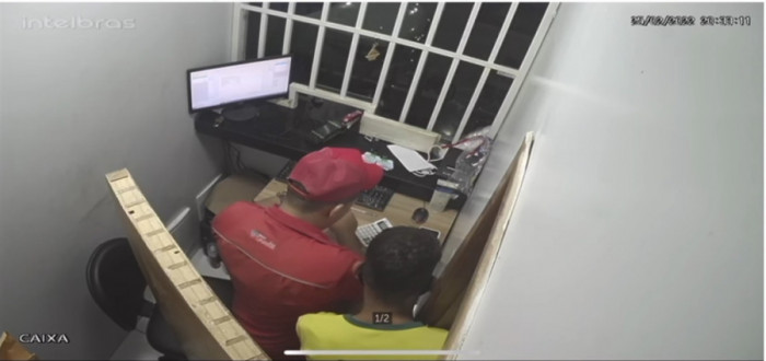 Assaltante usando camisa da seleção rendeu trabalhador no caixa do posto. Foto: Reprodução/Câmera de segurança. 